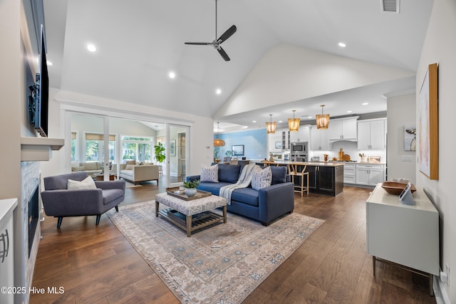 3478 Belle Meade Way NE, Leland, NC 28451 - living room with a fireplace, ceiling fan, high vaulted ceiling, dark wood-style flooring, and recessed lighting