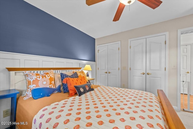 1484 Rays Bridge Rd, Whispering Pines, NC 28327 - bedroom featuring two closets, carpet, ceiling fan, and wainscoting