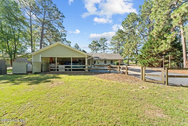 1484 Rays Bridge Rd, Whispering Pines, NC 28327 - rear view of house with an exterior structure, an attached carport, and an outbuilding