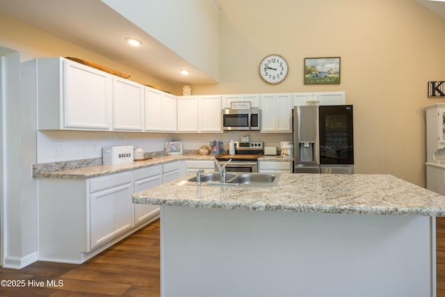 337 Brewington Rd, Clinton, NC 28328 - kitchen featuring appliances with stainless steel finishes, backsplash, dark wood-type flooring, a center island with sink, and white cabinetry