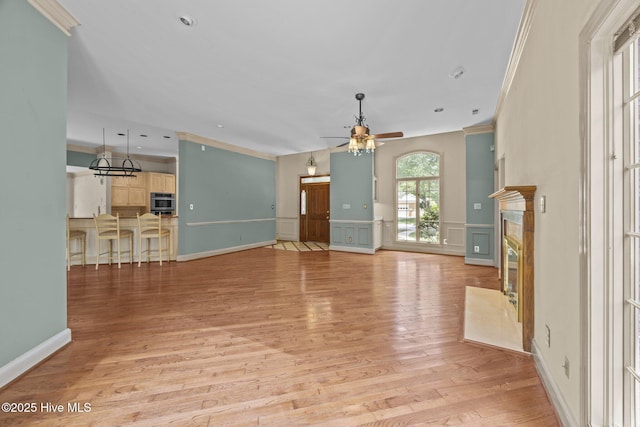 7006 Club House Dr, New Bern, NC 28562 - unfurnished living room featuring crown molding, a ceiling fan, light wood finished floors, a premium fireplace, and a decorative wall