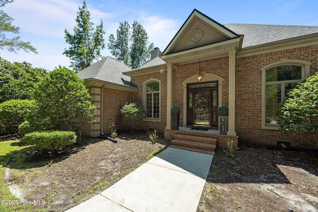 7006 Club House Dr, New Bern, NC 28562 - property entrance with a shingled roof, brick siding, and a chimney