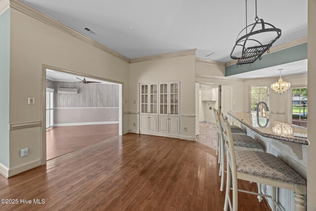 7006 Club House Dr, New Bern, NC 28562 - kitchen featuring stainless steel appliances, light brown cabinetry, wall chimney range hood, healthy amount of natural light, and ornamental molding