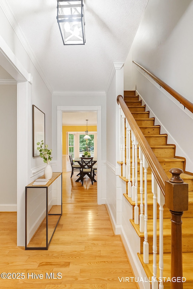 5025 Netherwood Rd, Rocky Mount, NC 27803 - corridor featuring stairway, light wood finished floors, ornamental molding, and a wainscoted wall