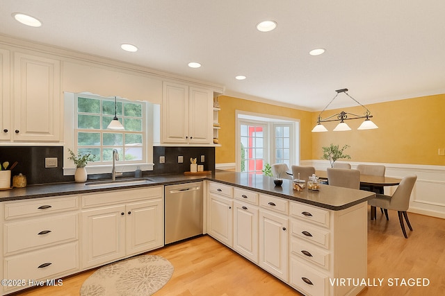 5025 Netherwood Rd, Rocky Mount, NC 27803 - kitchen with stainless steel dishwasher, dark countertops, a peninsula, a wainscoted wall, and light wood-type flooring