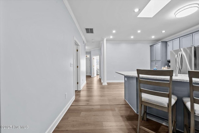 4465 Orchard Knob Ln, High Point, NC 27265 - kitchen with freestanding refrigerator, ornamental molding, gray cabinetry, recessed lighting, and a breakfast bar area
