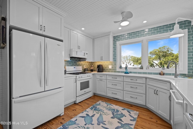 210 Upchurch Dr, Newport, NC 28570 - kitchen with white appliances, light countertops, backsplash, light wood-style floors, and recessed lighting