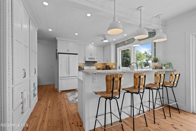 210 Upchurch Dr, Newport, NC 28570 - kitchen with white appliances, white cabinetry, a peninsula, a kitchen breakfast bar, and recessed lighting