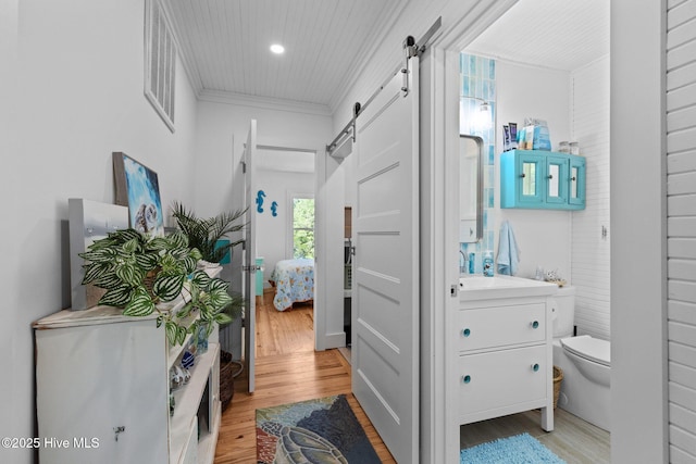 210 Upchurch Dr, Newport, NC 28570 - hall with a barn door, light wood-style floors, ornamental molding, and recessed lighting