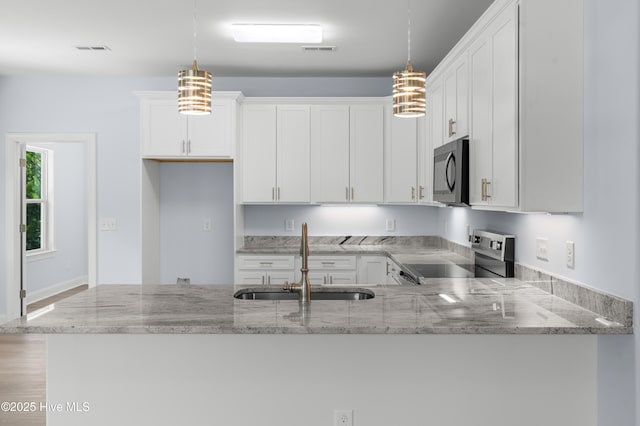 1990 Salisbury Rd, Southport, NC 28461 - kitchen with range, light stone counters, and a peninsula