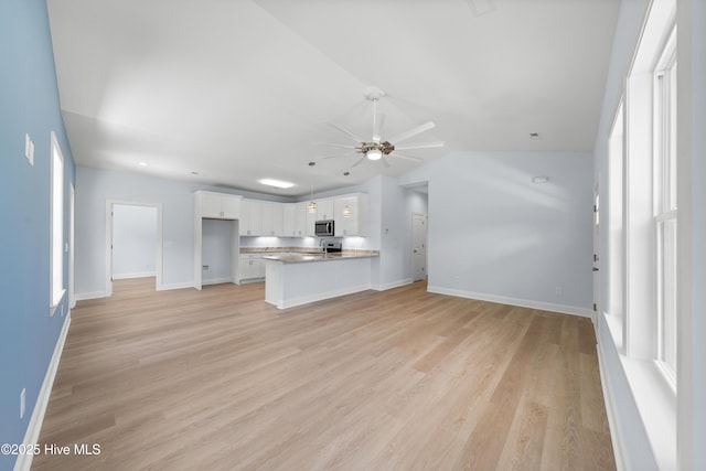 1990 Salisbury Rd, Southport, NC 28461 - unfurnished living room featuring ceiling fan, lofted ceiling, and light wood finished floors