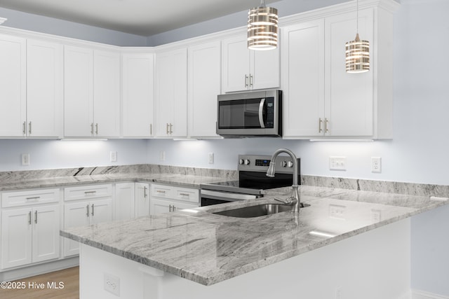 1990 Salisbury Rd, Southport, NC 28461 - kitchen with stainless steel appliances, white cabinetry, a peninsula, and hanging light fixtures