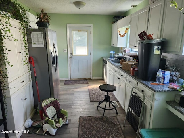 300 Morningside Dr, Vanceboro, NC 28586 - kitchen with appliances with stainless steel finishes, hardwood / wood-style floors, white cabinets, a textured ceiling, and dark countertops