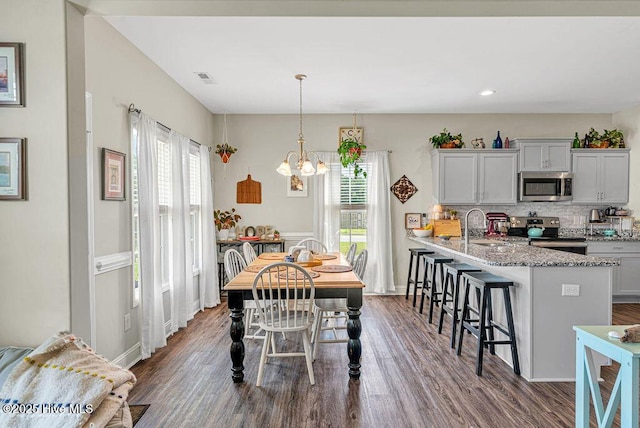 103 Baymeade Ct, Peletier, NC 28584 - dining area with healthy amount of natural light, dark wood finished floors, a chandelier, and recessed lighting