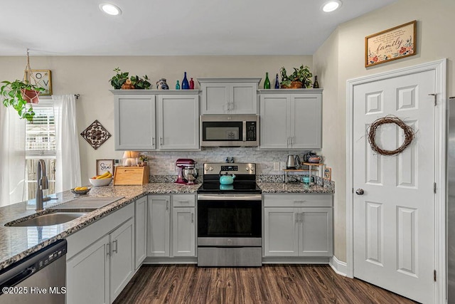 103 Baymeade Ct, Peletier, NC 28584 - kitchen with appliances with stainless steel finishes, decorative backsplash, dark wood-style floors, light stone countertops, and recessed lighting