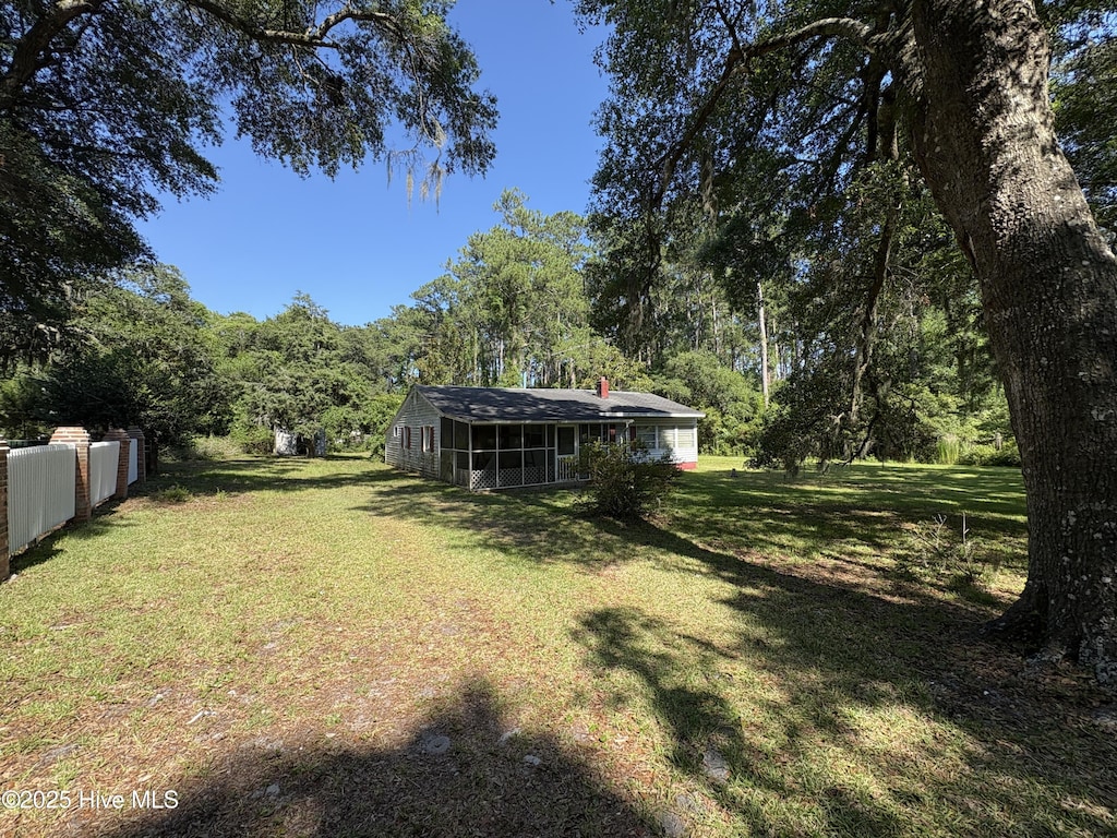 1677 Gause Landing Rd SW, Ocean Isle Beach, NC 28469 - view of yard featuring a sunroom and a forest view