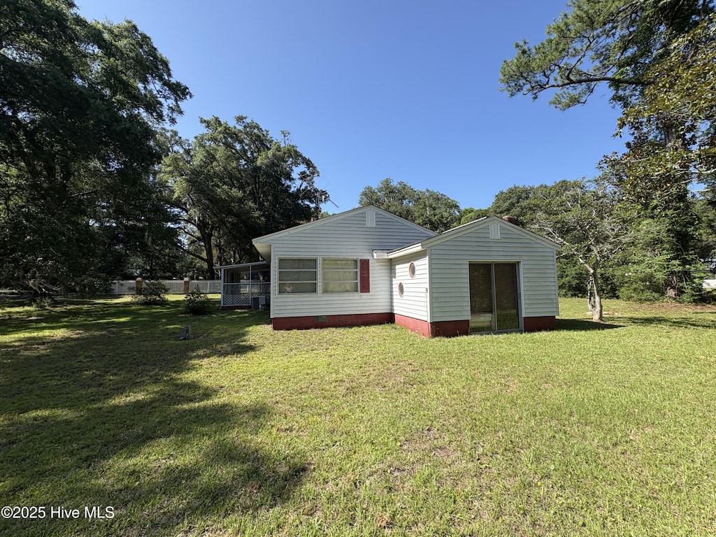 1677 Gause Landing Rd SW, Ocean Isle Beach, NC 28469 - back of house featuring a lawn and a sunroom