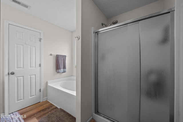 2950 Judge Manly Dr, New Bern, NC 28562 - bathroom with a shower stall, a bath, wood finished floors, and a textured ceiling