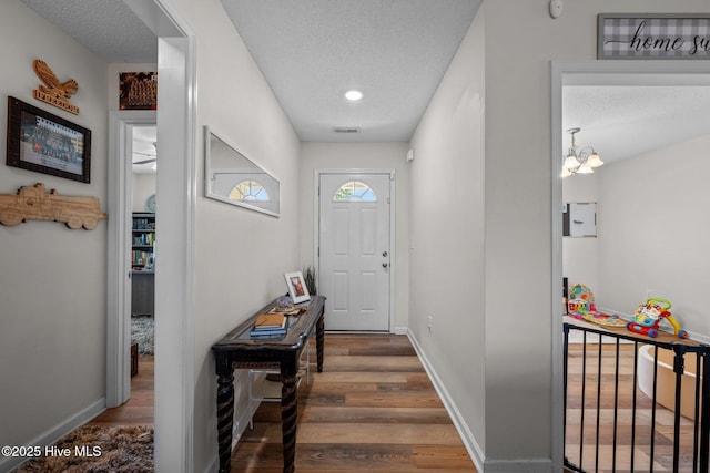 2950 Judge Manly Dr, New Bern, NC 28562 - doorway with wood finished floors, a textured ceiling, and a chandelier