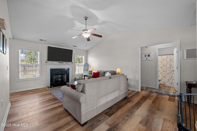 2950 Judge Manly Dr, New Bern, NC 28562 - living area with a ceiling fan, lofted ceiling, wood finished floors, a glass covered fireplace, and a textured ceiling
