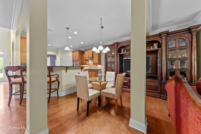 90 Shadow Creek Ct, Pinehurst, NC 28374 - dining room with ornamental molding, light wood-style flooring, arched walkways, a chandelier, and recessed lighting