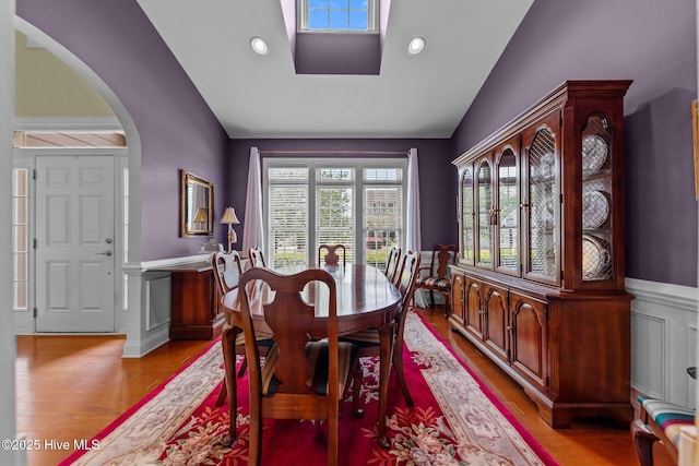 90 Shadow Creek Ct, Pinehurst, NC 28374 - dining space with arched walkways, vaulted ceiling, light wood-style flooring, wainscoting, and a decorative wall