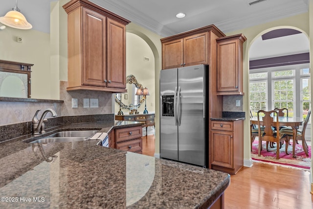 90 Shadow Creek Ct, Pinehurst, NC 28374 - kitchen featuring stainless steel refrigerator with ice dispenser, arched walkways, crown molding, brown cabinetry, and recessed lighting