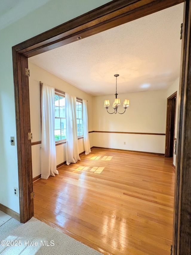106 Brown Bark Rd, West End, NC 27376 - empty room featuring a chandelier and light wood finished floors