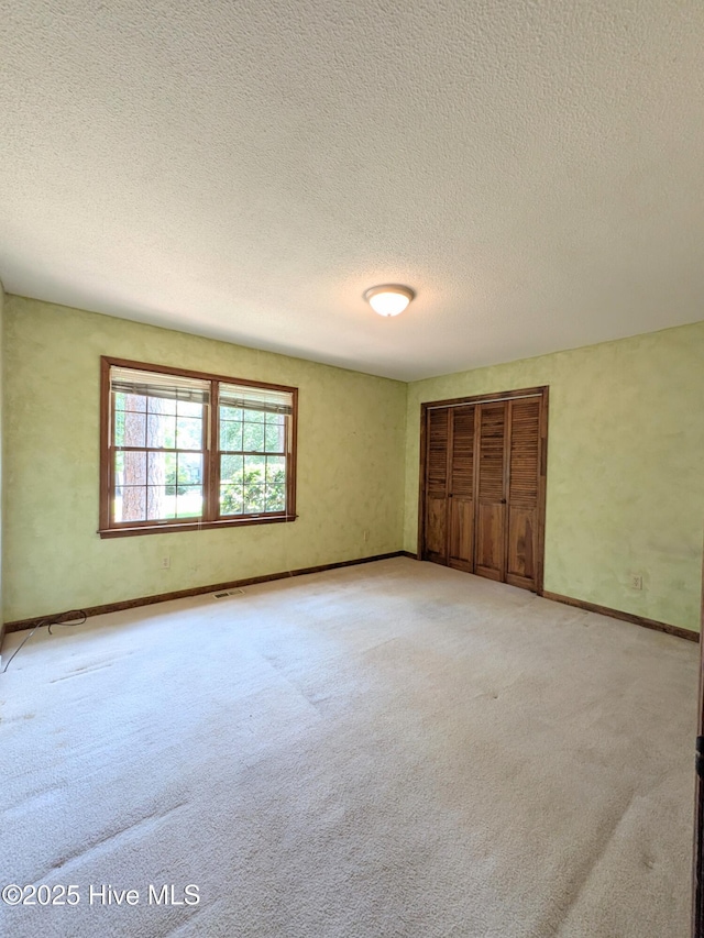 106 Brown Bark Rd, West End, NC 27376 - unfurnished bedroom featuring light carpet, a textured ceiling, and a closet