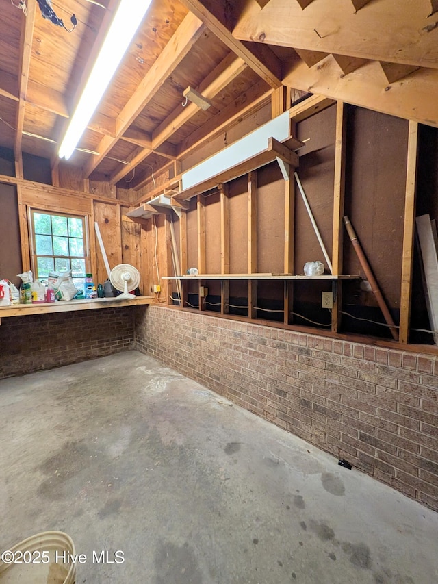 106 Brown Bark Rd, West End, NC 27376 - miscellaneous room with unfinished concrete floors and brick wall