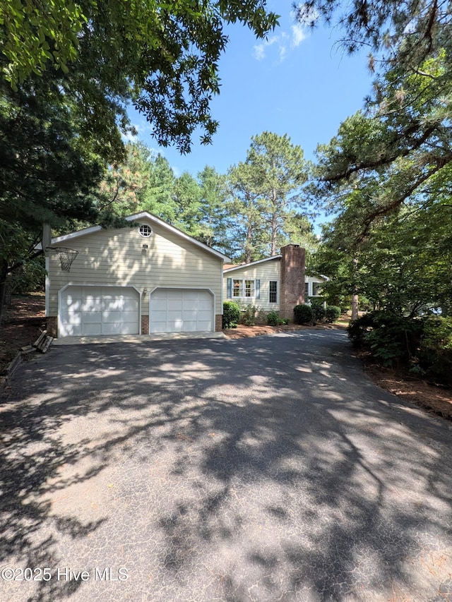 106 Brown Bark Rd, West End, NC 27376 - view of front of home featuring driveway, an outbuilding, and brick siding