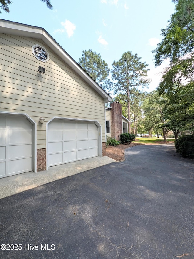 106 Brown Bark Rd, West End, NC 27376 - view of side of home featuring driveway, a garage, and brick siding