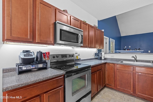110 Whiteleaf Dr, Jacksonville, NC 28546 - kitchen with appliances with stainless steel finishes, lofted ceiling, and brown cabinets
