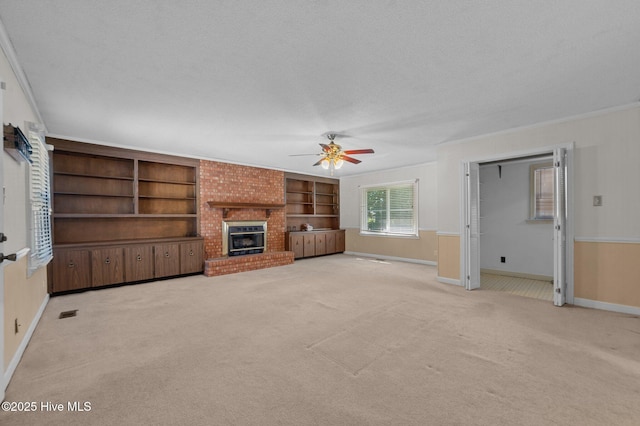 1603 Laurel St, Goldsboro, NC 27530 - unfurnished living room featuring ceiling fan, light carpet, a brick fireplace, crown molding, and a textured ceiling