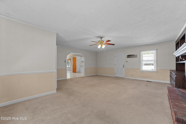1603 Laurel St, Goldsboro, NC 27530 - unfurnished living room with a ceiling fan, a textured ceiling, arched walkways, carpet, and ornamental molding