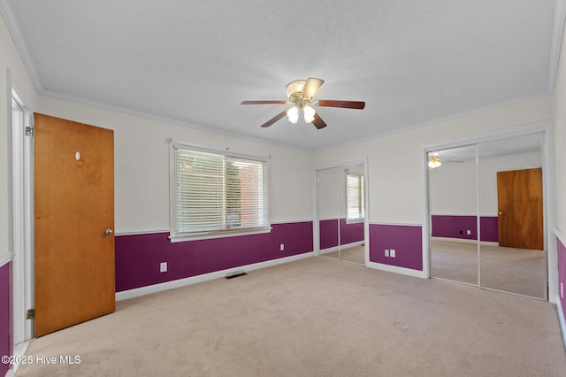 1603 Laurel St, Goldsboro, NC 27530 - unfurnished bedroom featuring carpet flooring, ornamental molding, two closets, and a ceiling fan