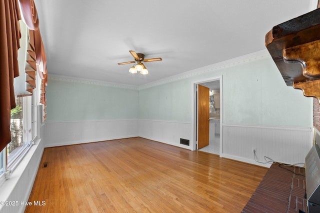 1603 Laurel St, Goldsboro, NC 27530 - empty room with a ceiling fan, wainscoting, wood finished floors, and ornamental molding