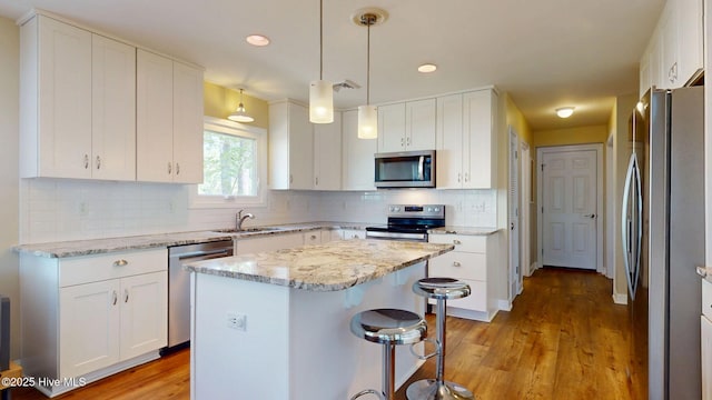 5410 Trade Winds Rd, New Bern, NC 28560 - kitchen with appliances with stainless steel finishes, a kitchen island, white cabinets, and recessed lighting