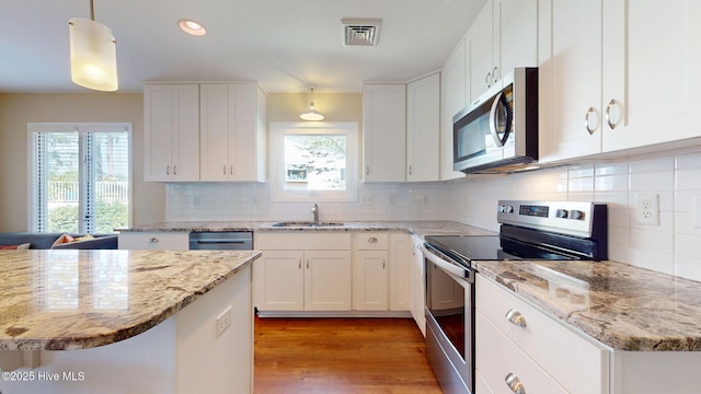 5410 Trade Winds Rd, New Bern, NC 28560 - kitchen with appliances with stainless steel finishes, light wood-type flooring, white cabinetry, and recessed lighting