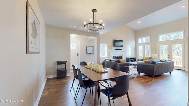 5410 Trade Winds Rd, New Bern, NC 28560 - dining area featuring healthy amount of natural light, wood finished floors, a chandelier, a glass covered fireplace, and lofted ceiling