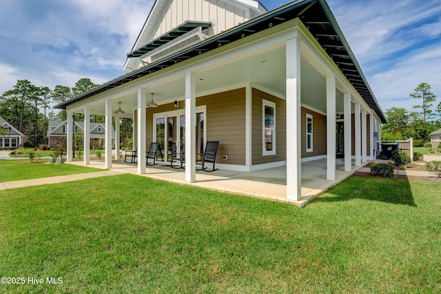 2233 Whiskey Branch Dr, Wilmington, NC 28409 - rear view of house featuring board and batten siding, a yard, a patio, and ceiling fan
