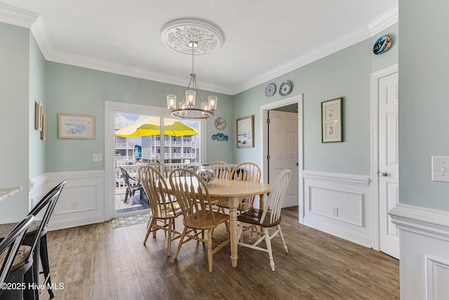 1726 W Beach Dr, Oak Island, NC 28465 - dining room featuring a chandelier, ornamental molding, wood finished floors, a wainscoted wall, and a decorative wall