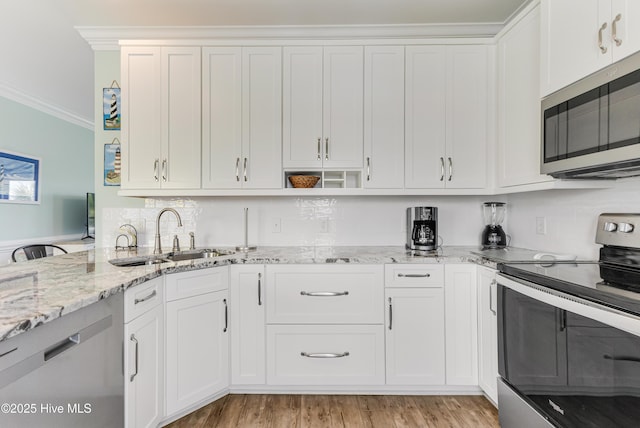 1726 W Beach Dr, Oak Island, NC 28465 - kitchen featuring appliances with stainless steel finishes, ornamental molding, white cabinets, light stone counters, and tasteful backsplash