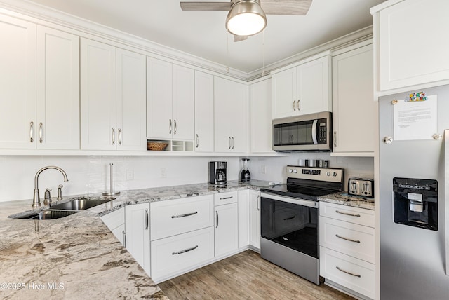 1726 W Beach Dr, Oak Island, NC 28465 - kitchen featuring stainless steel appliances, white cabinetry, and light stone counters