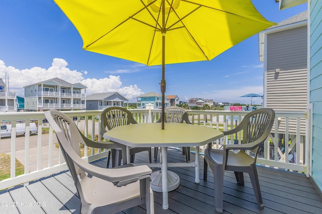 1726 W Beach Dr, Oak Island, NC 28465 - wooden deck featuring outdoor dining area and a residential view