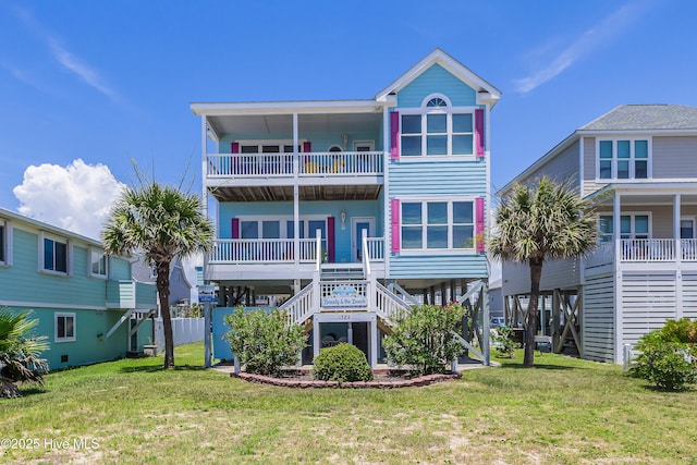 1726 W Beach Dr, Oak Island, NC 28465 - back of house featuring a balcony, stairs, and a lawn