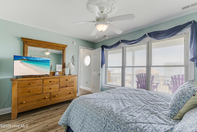 1726 W Beach Dr, Oak Island, NC 28465 - bedroom featuring wood finished floors, multiple windows, and a ceiling fan