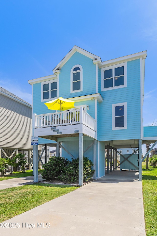 1726 W Beach Dr, Oak Island, NC 28465 - coastal inspired home featuring a carport and concrete driveway