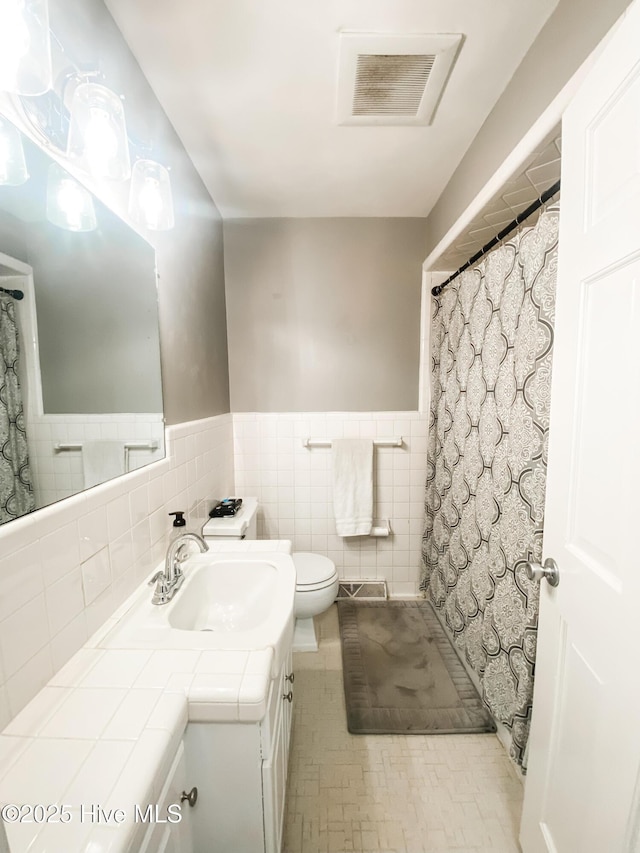 1721 Nash St NW, Wilson, NC 27893 - bathroom with vanity, a wainscoted wall, and a shower with shower curtain