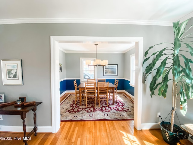 1721 Nash St NW, Wilson, NC 27893 - dining area with light wood finished floors, ornamental molding, and a chandelier